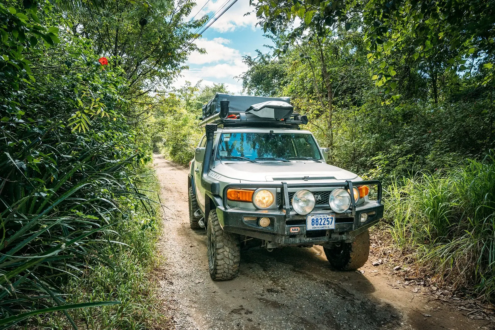 4x4 vehicle on the unpaved dirt road leading into Pavones, navigating the final jungle section before the village