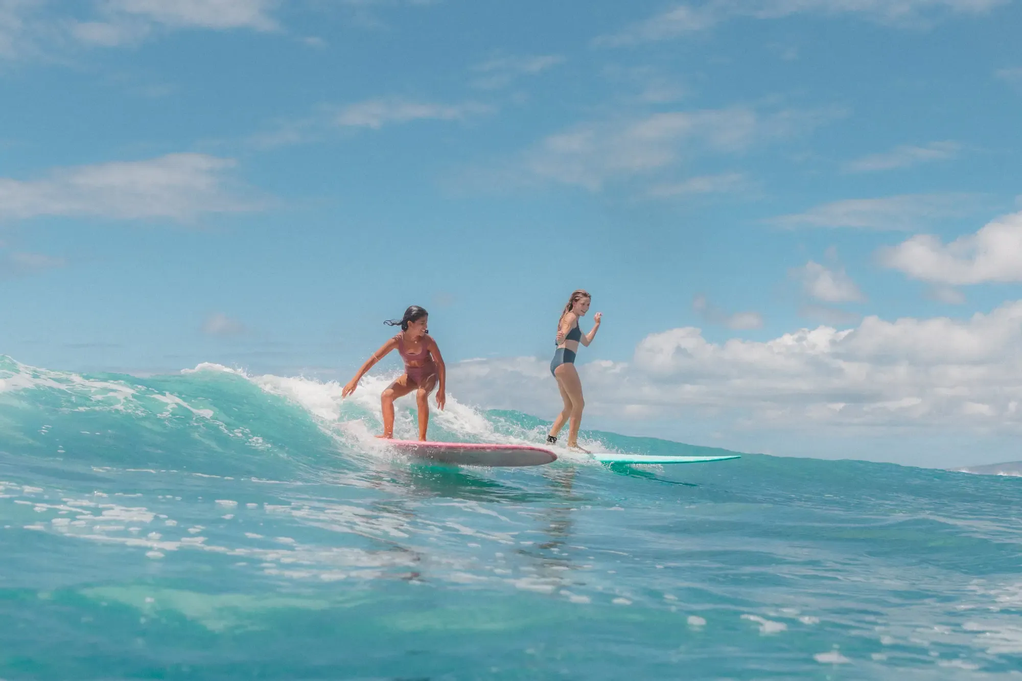 Beginner surfer learning on a soft-top board in gentle whitewater at Pavones, Costa Rica