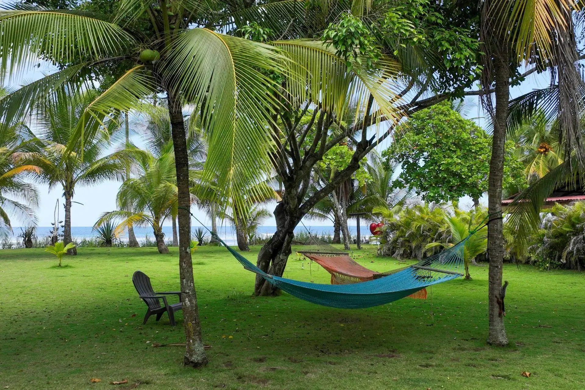 Relaxed outdoor dining area at the surf camp in Pavones, jungle and coast visible in the background