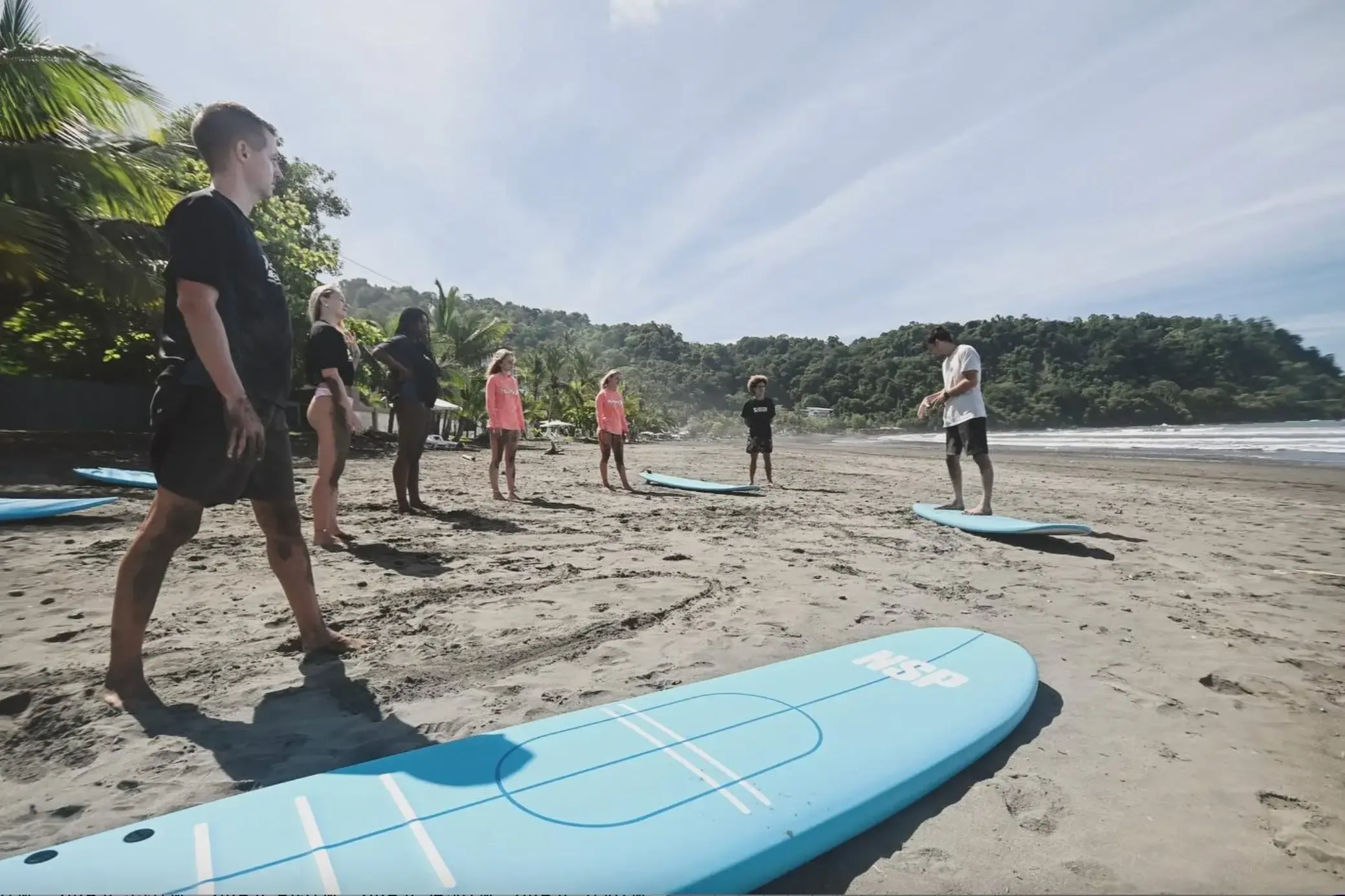 Surf coach giving beginner-friendly feedback to a student in shallow water at a Pavones surf camp