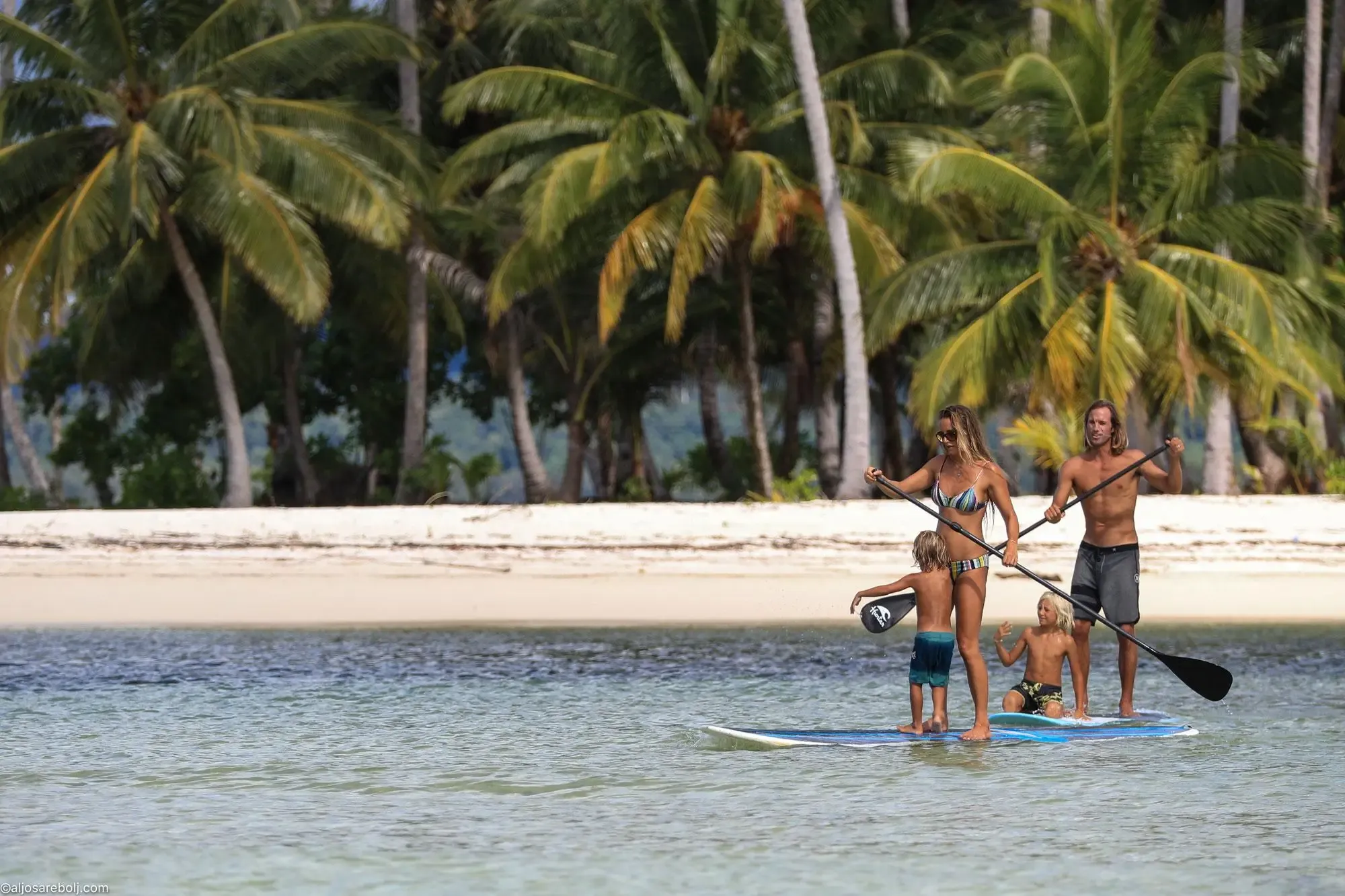 Family with surfboards on a calm beach at a Pavones family surf camp