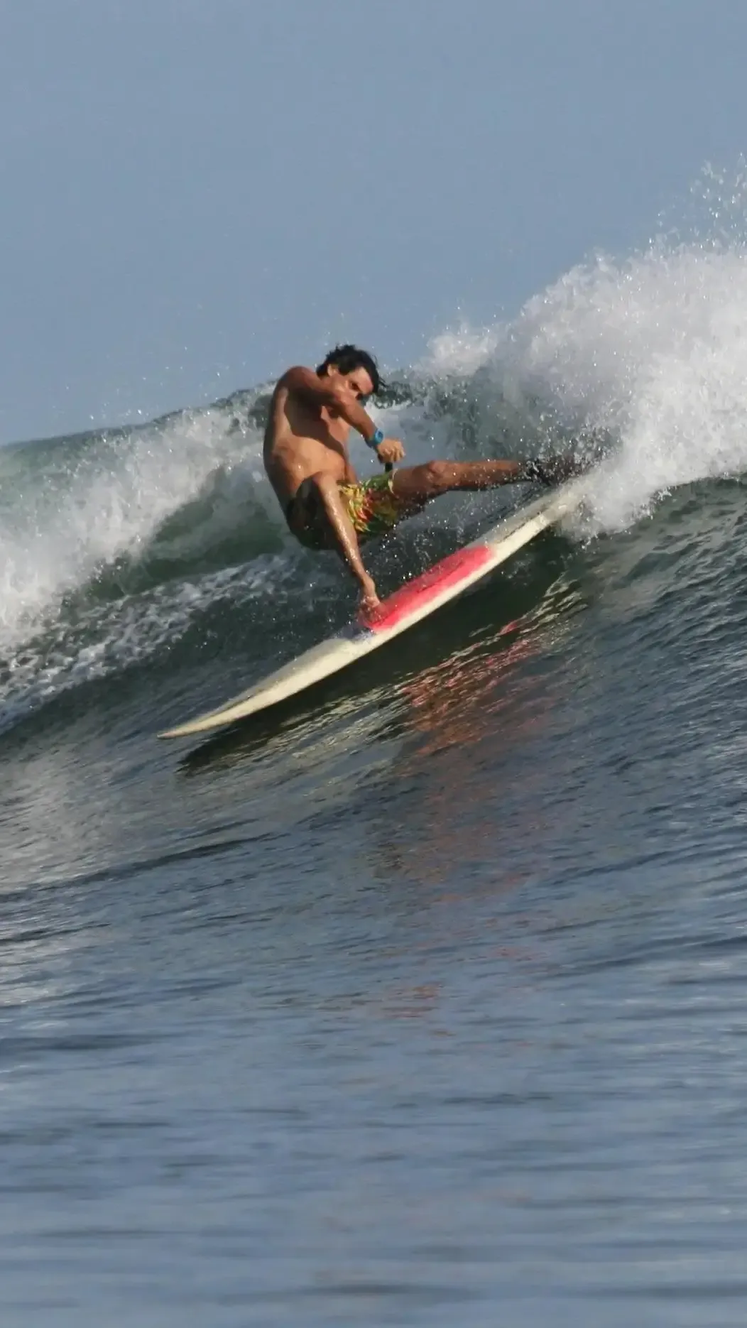 Surfer carving a turn on a breaking wave at Pavones, portrait crop for mobile