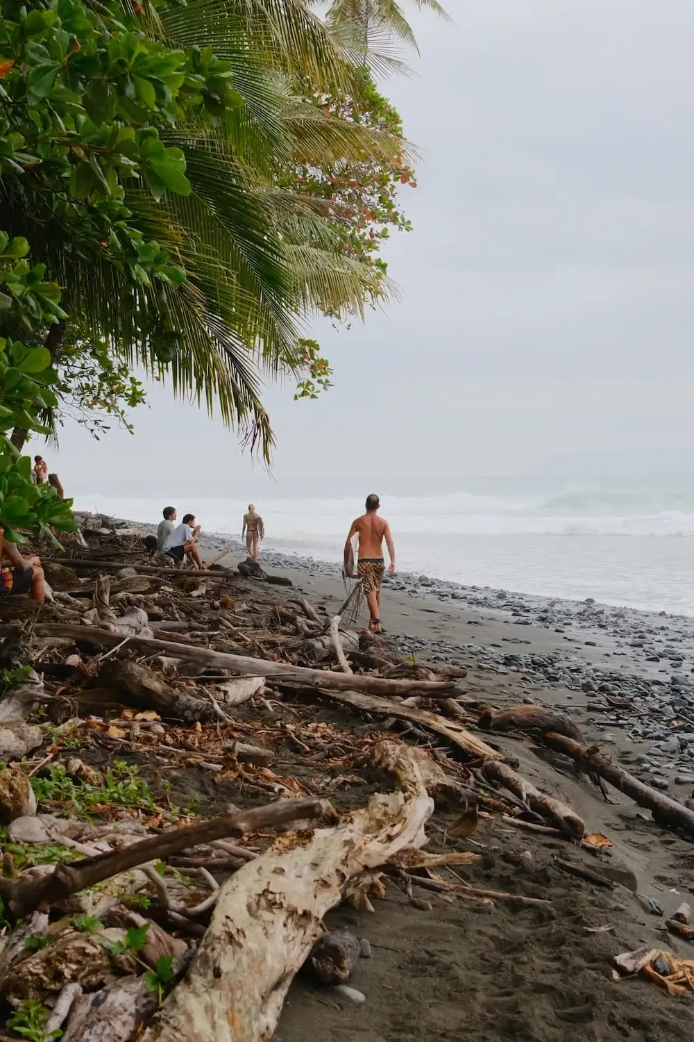 Surfers walking toward the Pavones point break to paddle out, southern Costa Rica