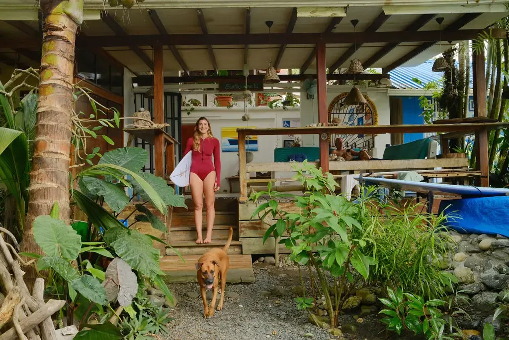 Travellers relaxing in a surf hostel common area with hammocks in Pavones