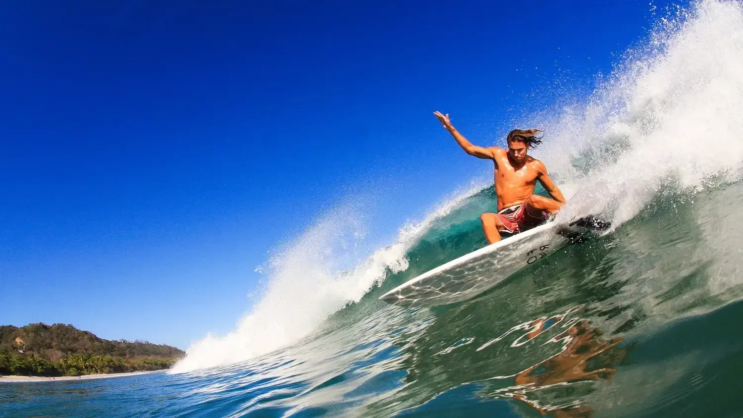 Surfer on the long left-hand wall at Pavones surf break in southern Costa Rica