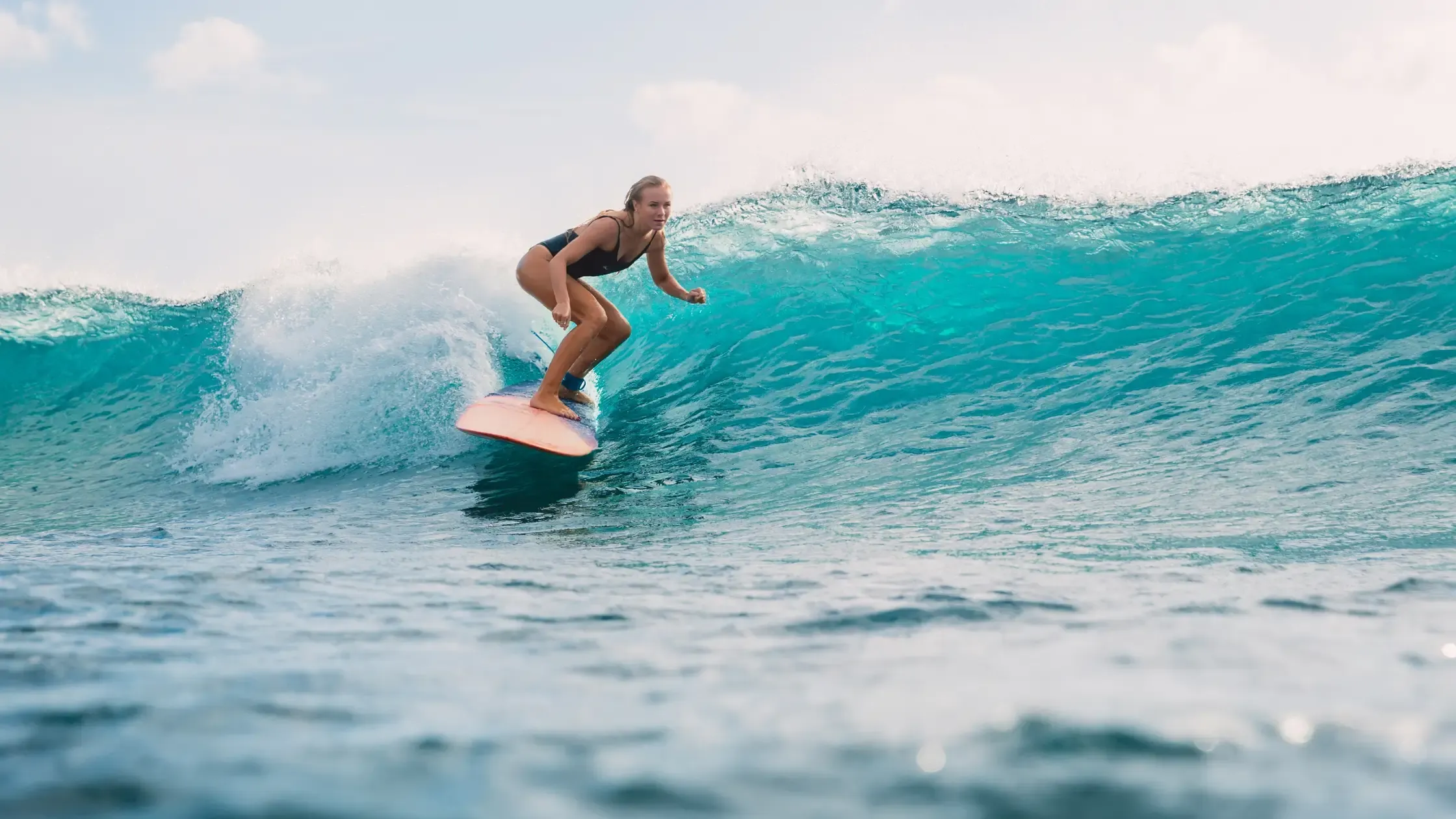 Surfer riding the long left-hand point break at Pavones surf camp, Costa Rica